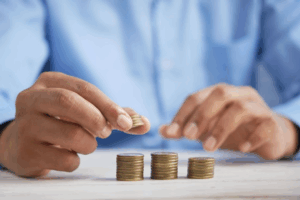 Un homme tient de la monnaie et les compte en pile d'environ 10 pièces.