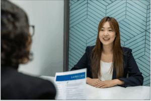 Candidate préparant son oral de motivation CRPE, assise face au jury, souriante et professionnelle lors d’un entretien simulé.